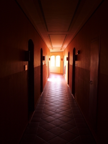 dark hallway with light streaming in through angled doors